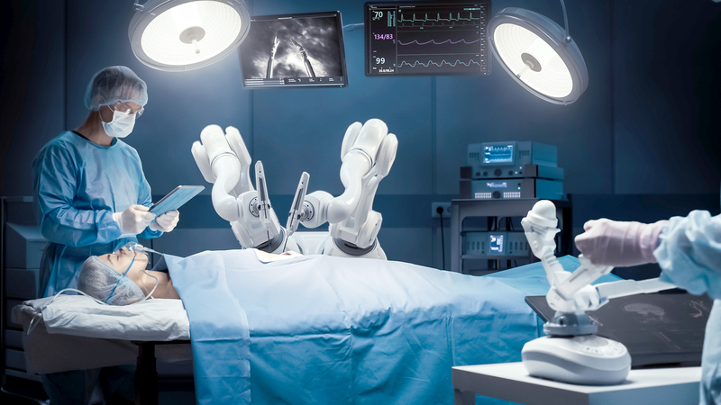 Auf dem Bild sind medizinische Roboter in einem Operationssaal zu sehen, die mit einem Patienten arbeiten, während ein Arzt eine digitale Anleitung verfolgt.