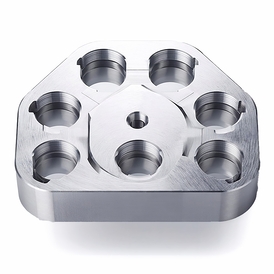 Auf dem Bild ist ein präzise gefertigtes Metallteil mit mehreren Bohrungen zu sehen.