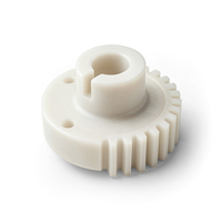 Auf dem Bild ist ein mechanisches Teil in Form eines Zahnrads aus weißem Kunststoff zu sehen.